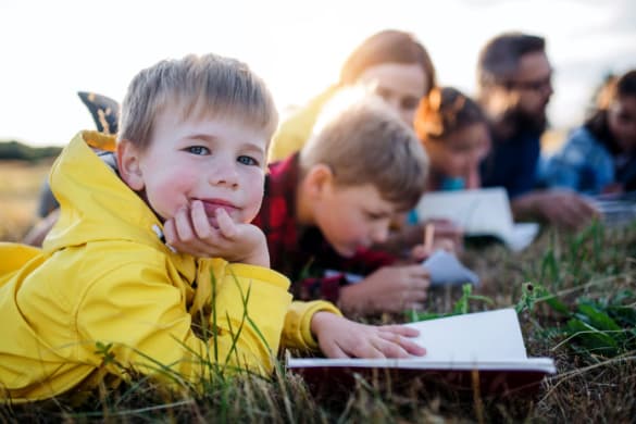 Children sitting in the grass on a field trip
