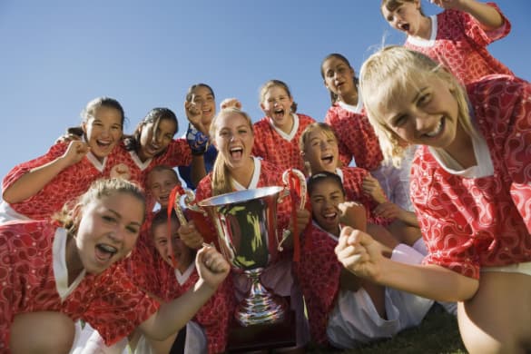 A girl's soccer team celebrates a victory