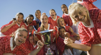 a team cheering around a trophy